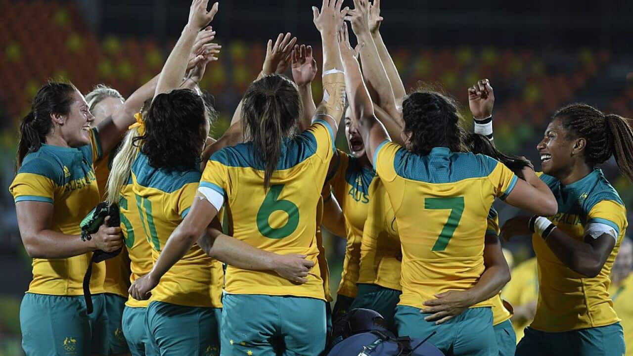 Australia's players celebrate victory in the womens rugby sevens gold medal match between New Zealand and Australia.