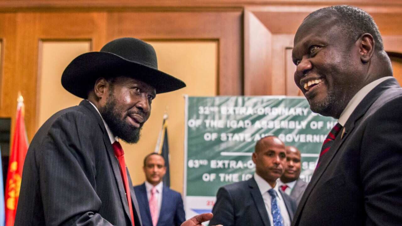 file photo dated Thursday, June 21, 2018, South Sudan's President Salva Kiir, left, and opposition leader Riek Machar, right, shake hands during peace talks