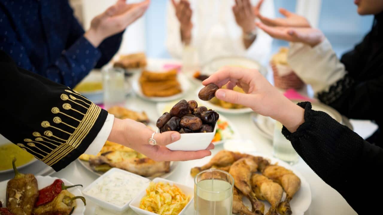 Muslim family and friends at Ramadan Iftar food table