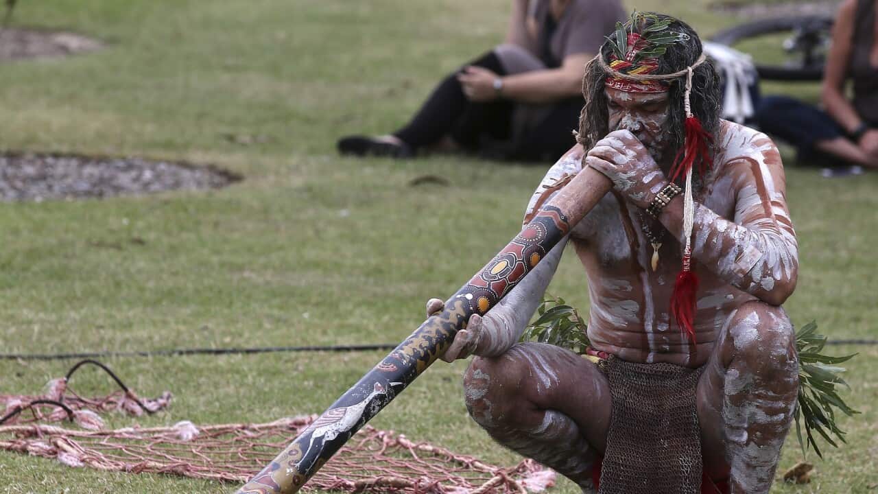 A man plays a didgeridoo at an Australia Day event