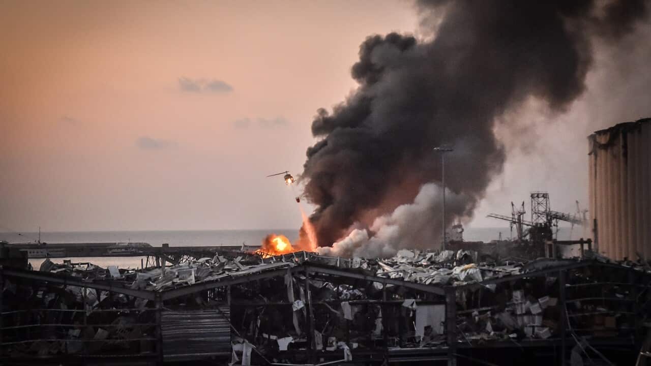 A military helicopter trying to put out a fire at the Beirut port after the explosion