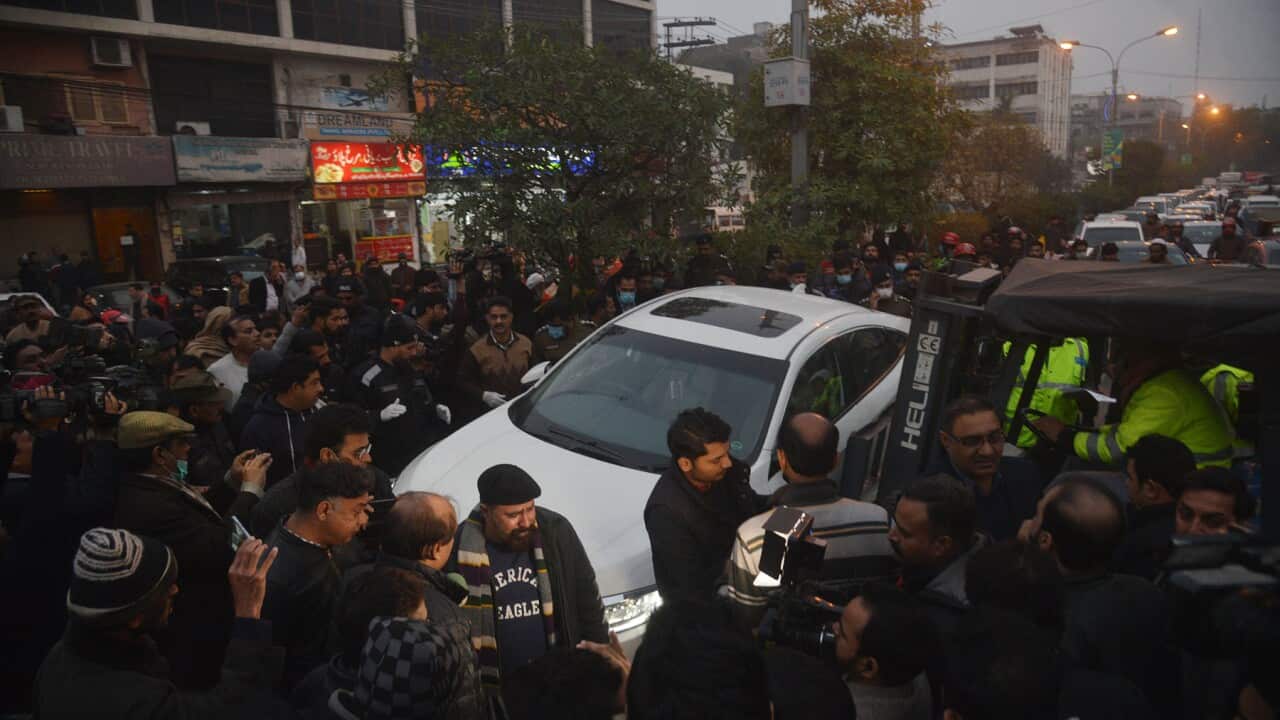 Media surround a car at the site of the Pakistan shooting.