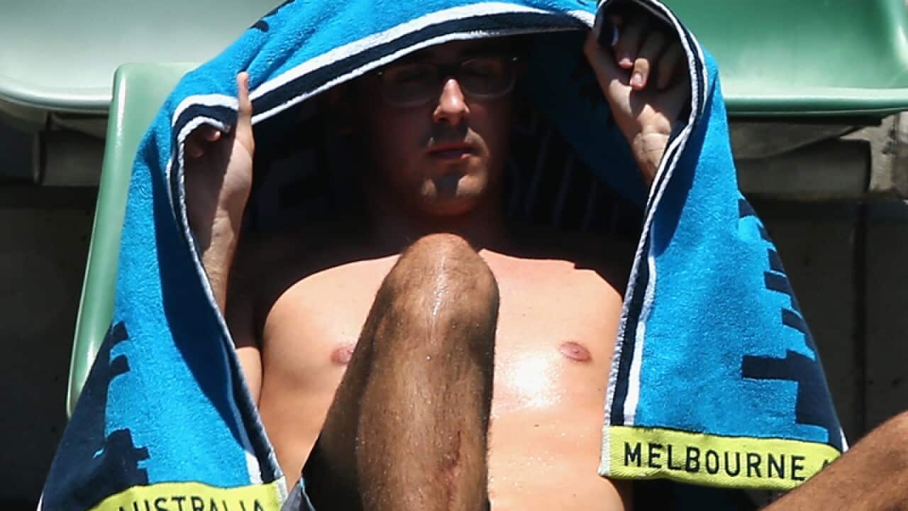 A man shields himself from the sun at the Australian Open