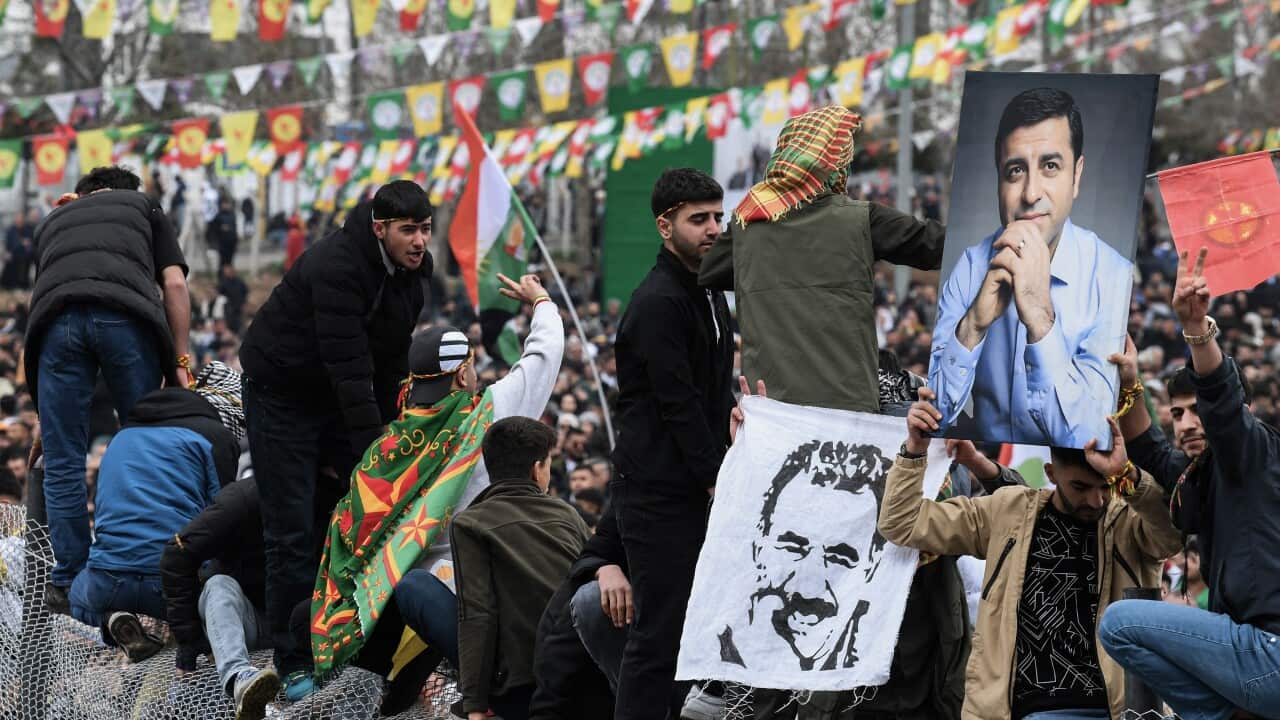 Men hold portraits of their leaders as they protest