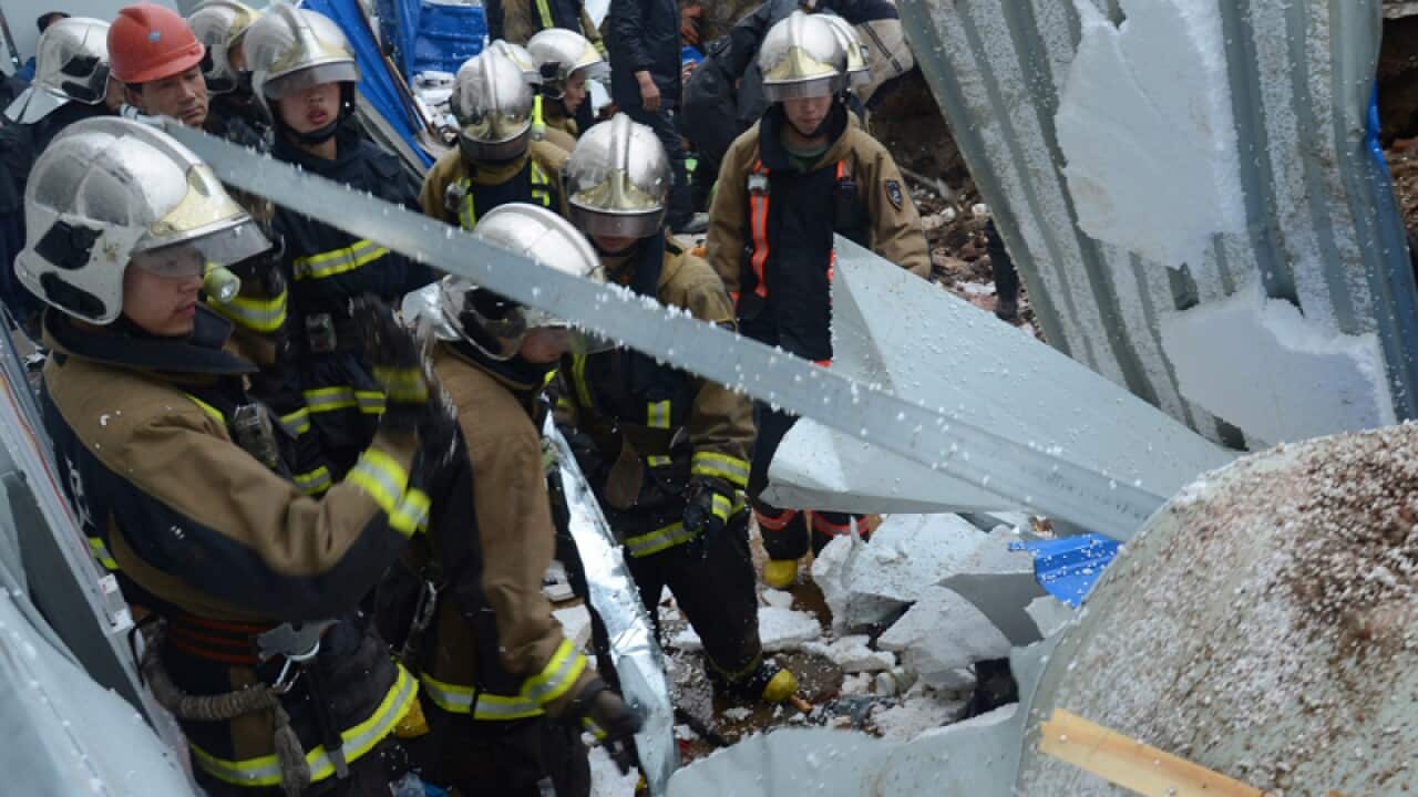 Rescuers at the site where a rainstorm-triggered wall collapse, China