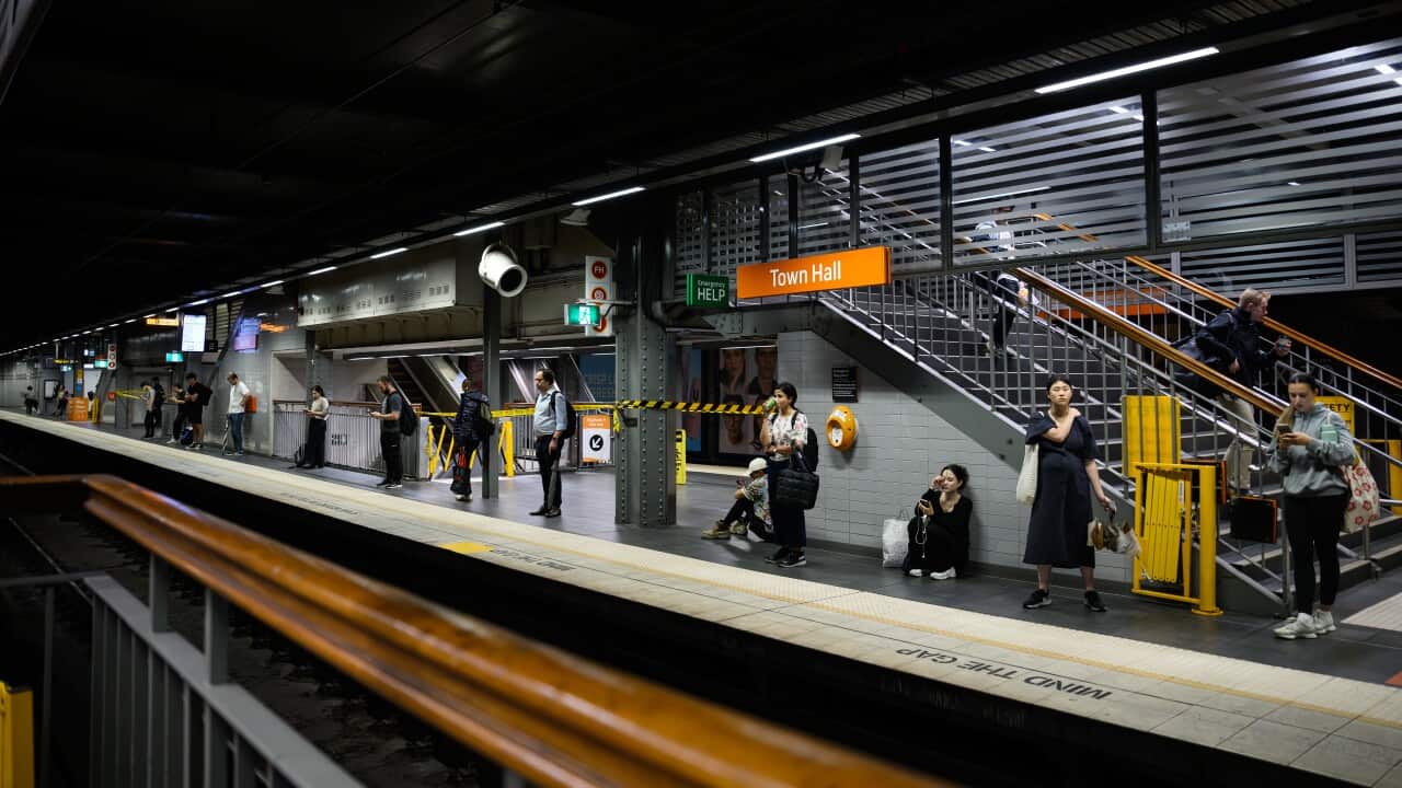 Commuters are seen as they await the arrival of a train at Town Hall Station in Sydney.
