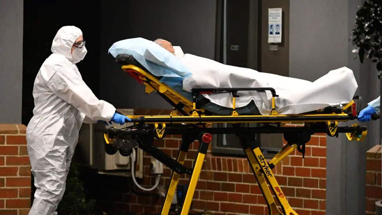Healthcare workers transport a person into a patient transport vehicle at an aged care facility in Melbourne in June, 2021. As of 21 July, 2022, some 6,000 aged care residents across the country had COVID-19, according to the Aged & Community Care Provide