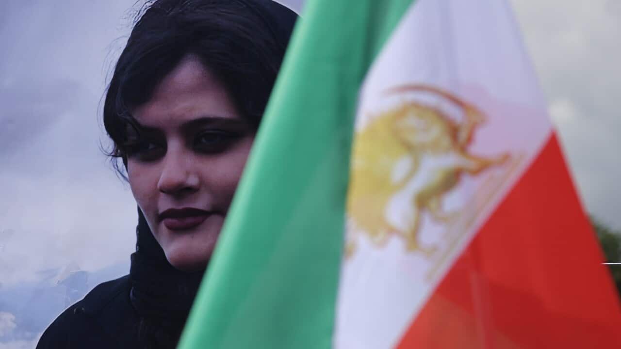 A portrait of Mahsa Amini stands next to an Iranian opposition flag during a protest in Germany (Getty)