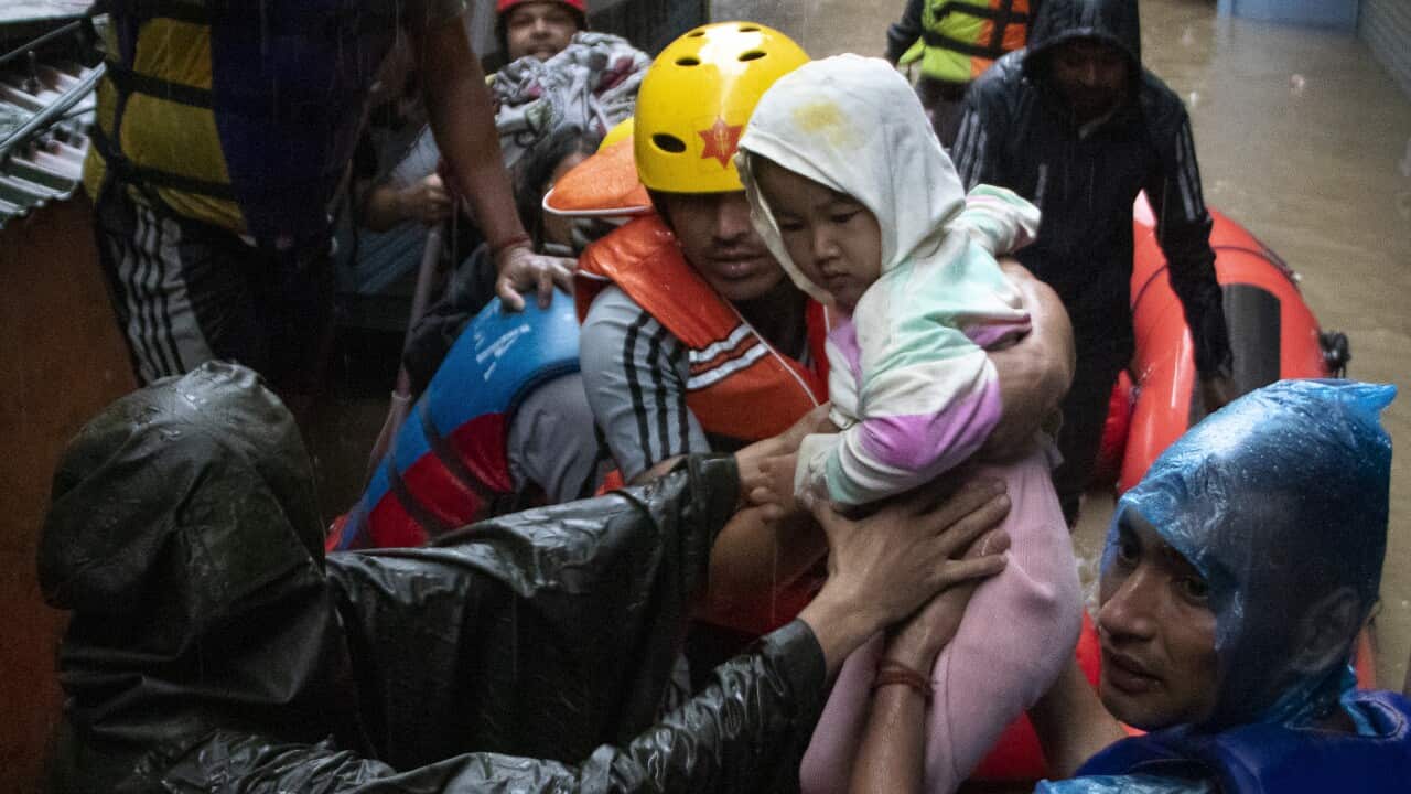 Rescue workers saving a child from floods.