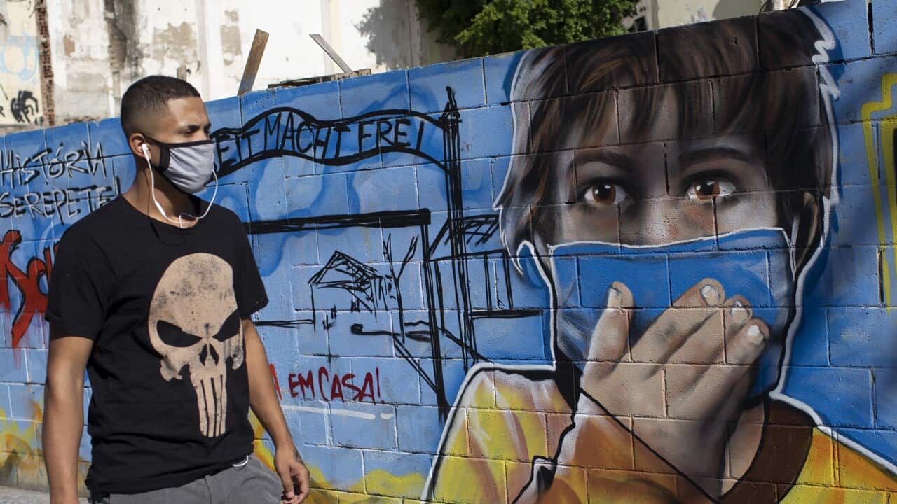 : A man walks past a mural in honour of health workers in Rio de Janeiro, Brazil (AAP)