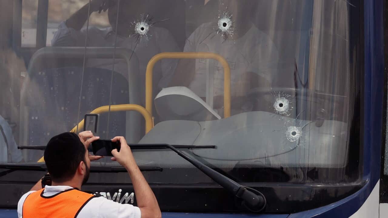 Israeli officers inspect a bus with bullet holes at the scene of the shooting incident in Jerusalem (AAP)
