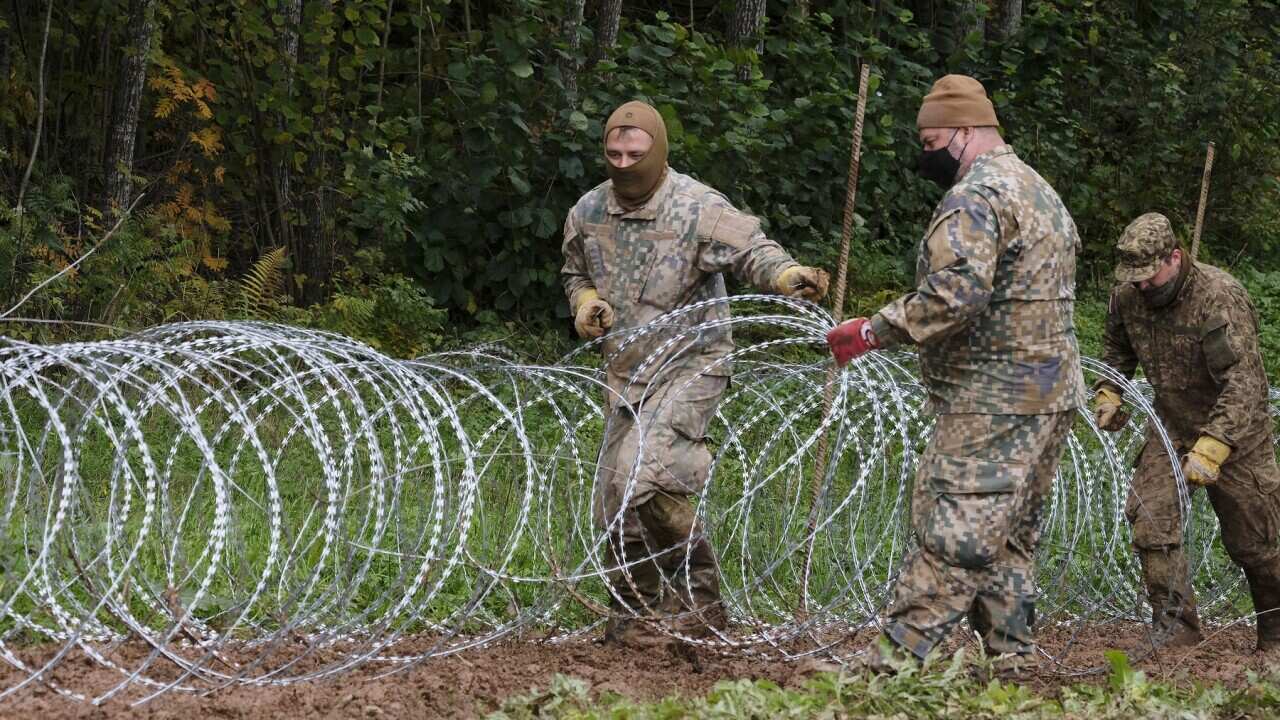 A barbed wire fence is erected on the Belarusian border with Latvia