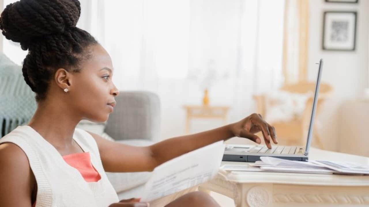 Black woman paying a fine on laptop