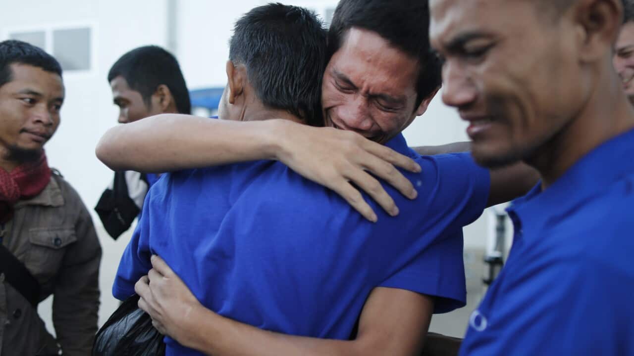 An unidentified sailor (2-R) hugs a fellow hostage upon their arrival at the Jomo Kenyatta International Airport after they were released by Somali pirates.