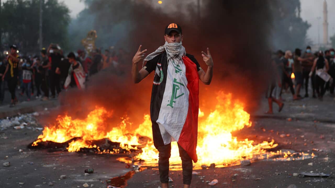 An anti-government protester flashes the victory sign during a demonstration, in Baghdad, Iraq.