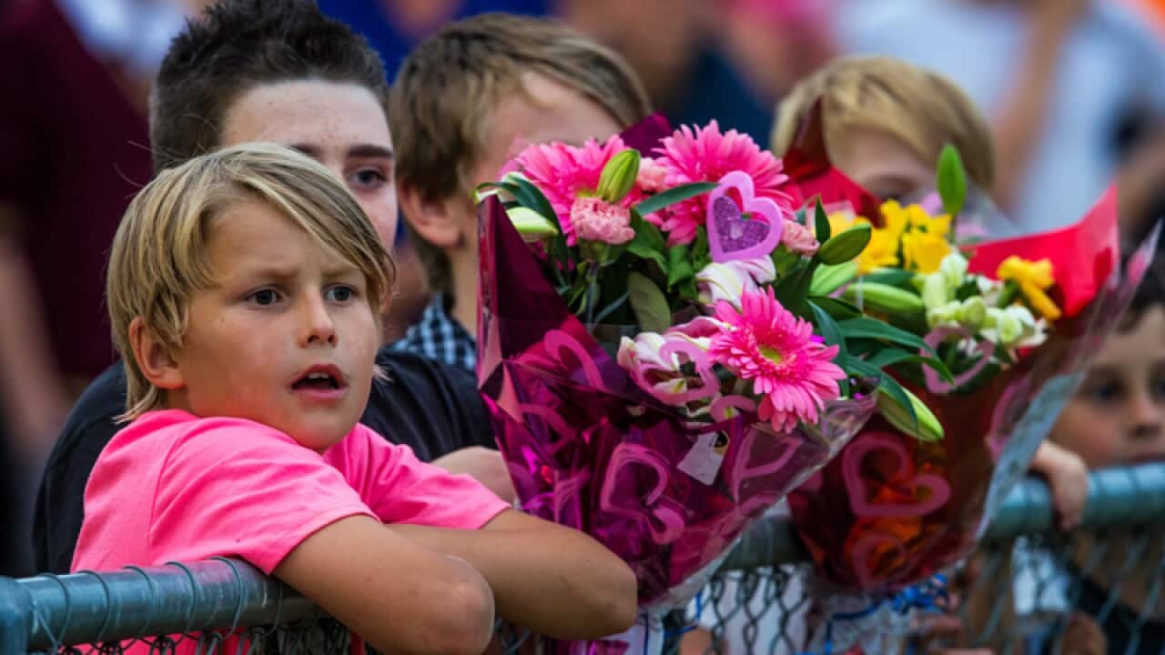 Mourners congregate at an evening vigil for Luke Batty