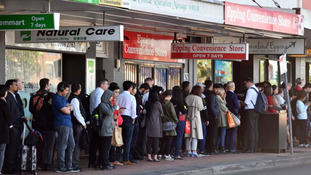 Commuters wait for buses at Epping train station in Sydney,
