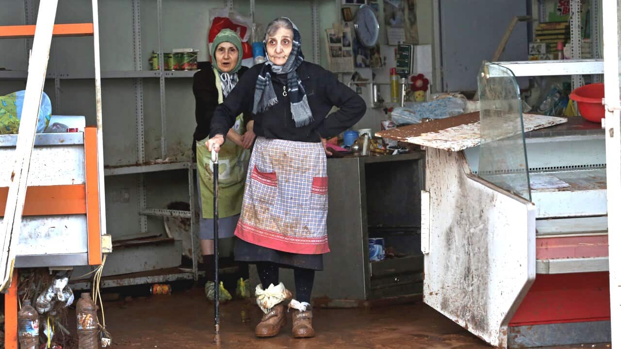 Two elderly women stand inside their damaged store in Mandra, Western Attica, Greece 16 November 2017