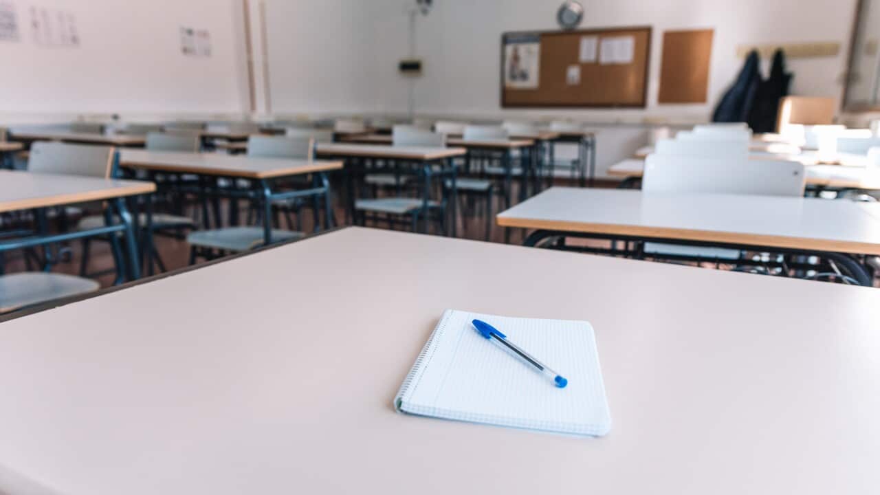 Notebook with a pen on a table in a classroom at a school