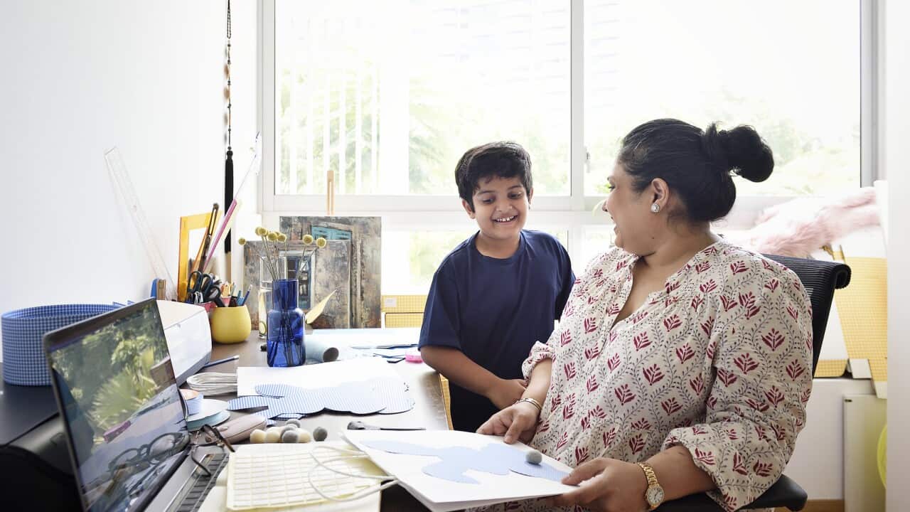 A woman at her home desk with her son