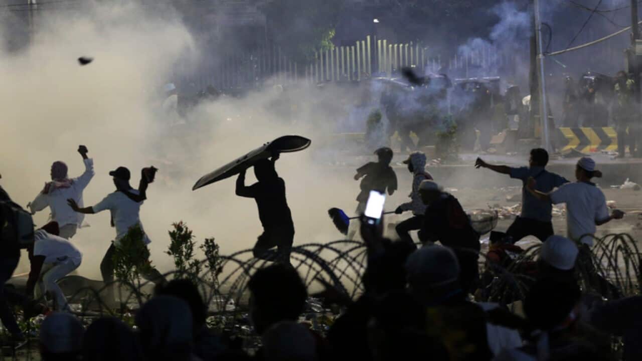 Supporters of the losing presidential candidate throw rocks towards police in Jakarta.
