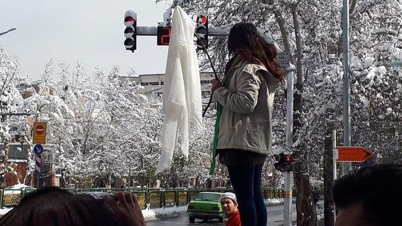 A woman protests Iran's compulsory hijab rule. 
