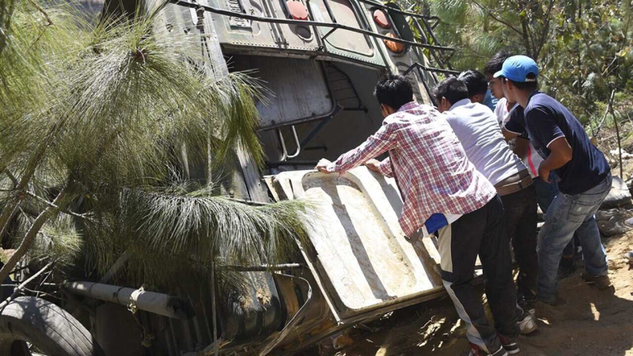 People help in the rescue effort after a bus crash in Guatemala