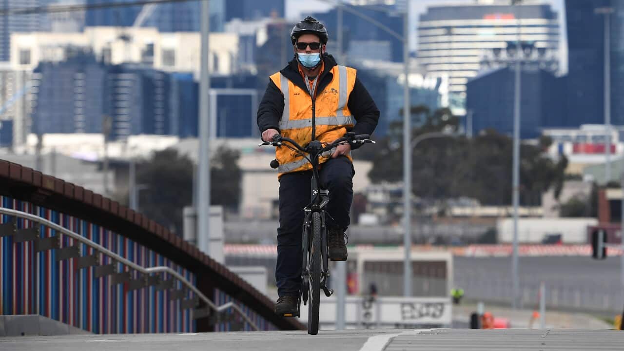 A cyclist wearing a face mask crosses an overpass in Melbourne where stage four restrictions are in force across metropolitan Melbourne.