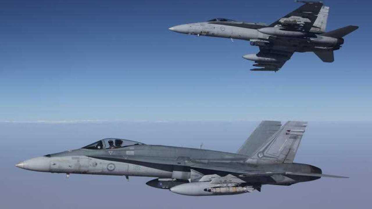 F/A-18A Hornets from Australia's Air Task Group fly in formation with a Royal Australian Air Force KC-30A Multi Role Tanker Transport aircraft.