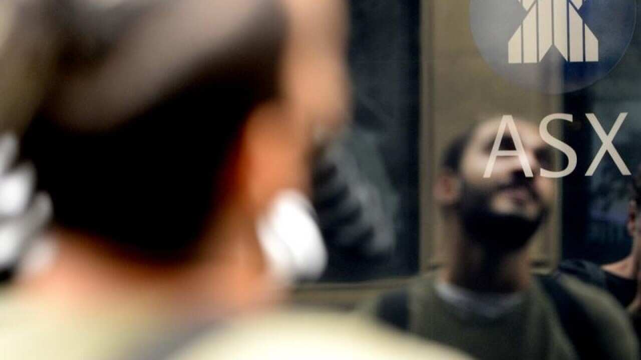 Man reflected on the ASX trading board.