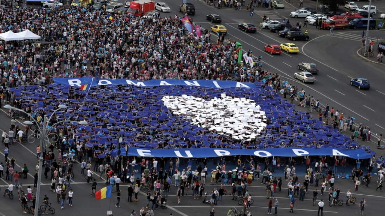 Romanian volunteers raise blue and white placards above their heads to form a heart like shape -ROMANIA LOVES EUROPE- during a civil society rally