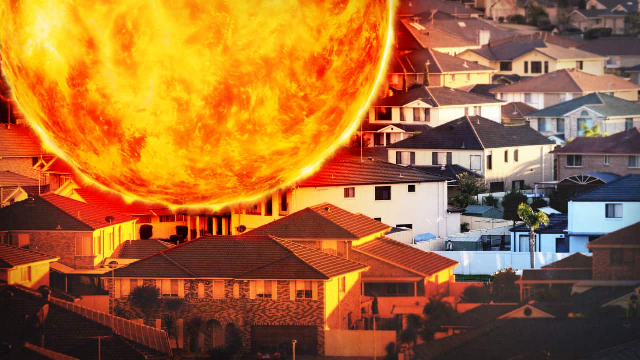 A hot, glowing sun superimposed over an aerial view of buildings, all with black roofs.