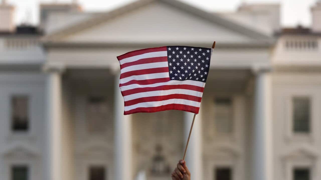 A US flag is waved during an immigration rally outside the White House, in Washington, Sept. 2017