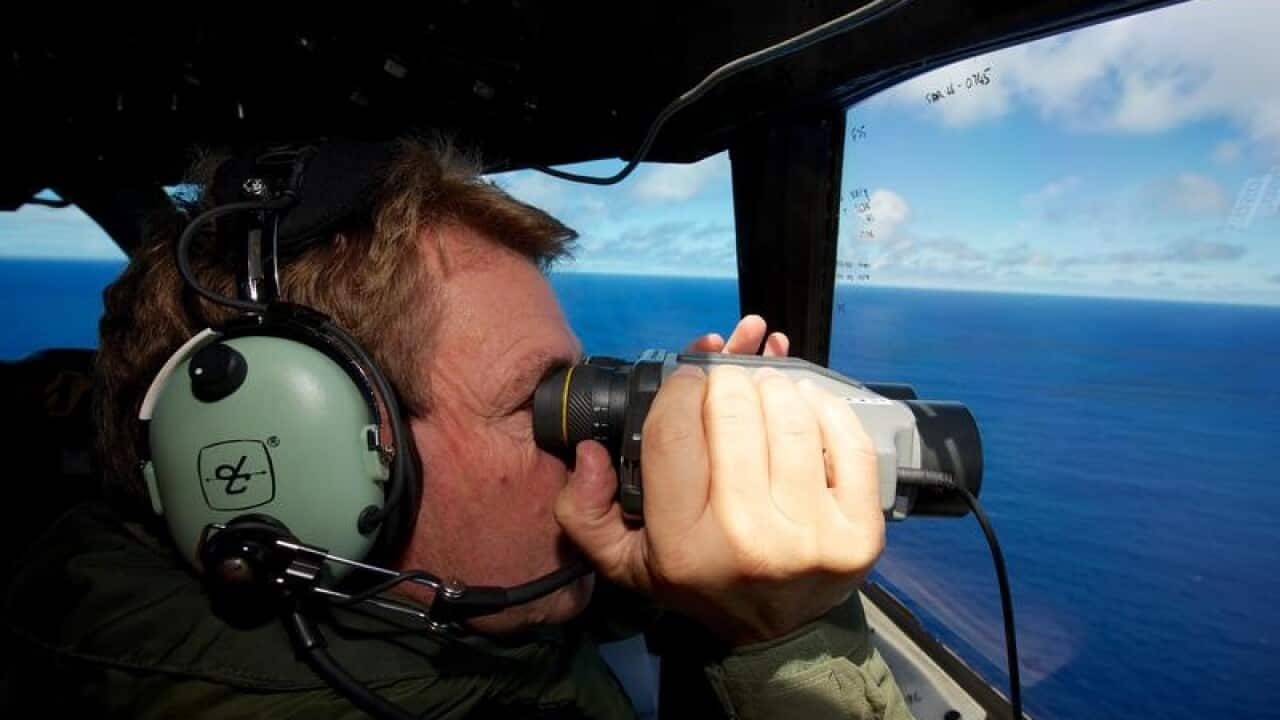 An air force spotter looks out for missing Malaysia Airways MH370