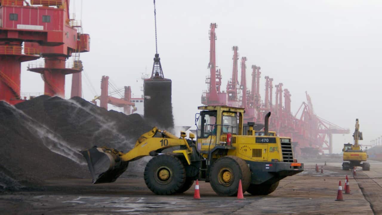 A bucket grab unloads coal on a quay at the Port of Rizhao in Rizhao city, east China