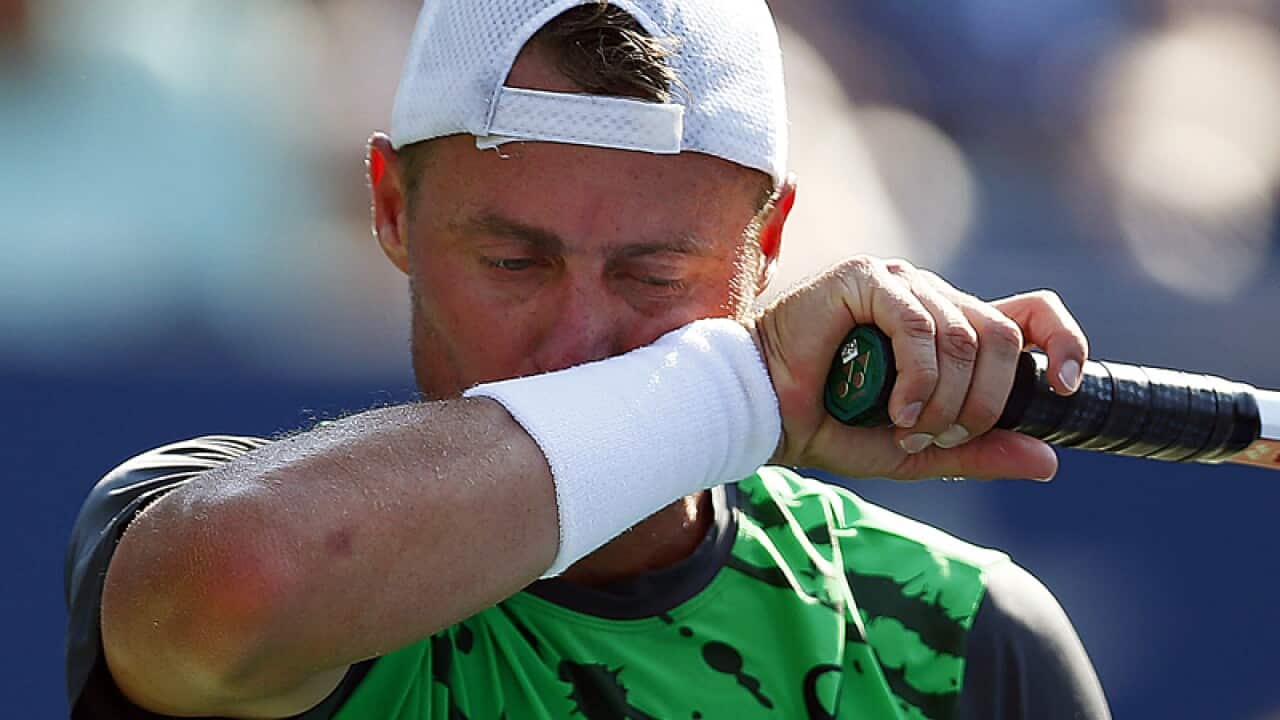 Lleyton Hewitt, of Australia, wipes sweat from his face.
