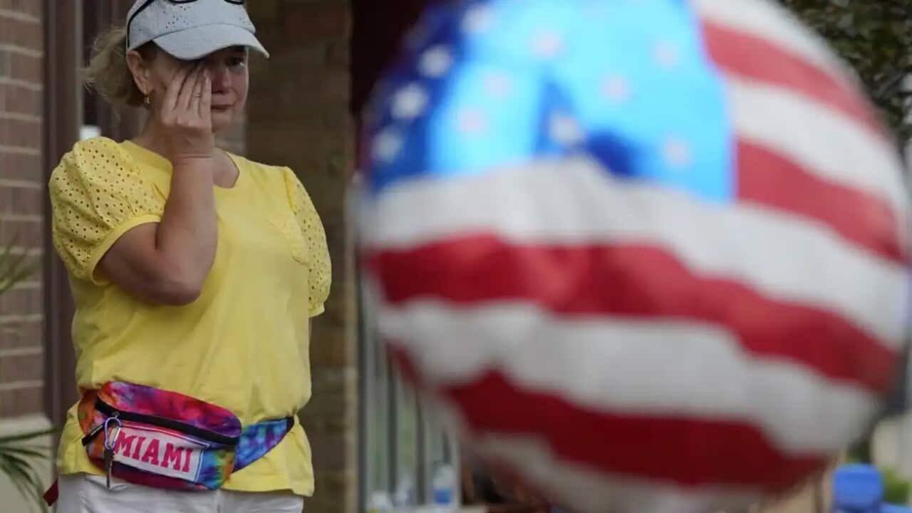 A woman wipes away tears as the community grieves following the shooting in Chicago. 
