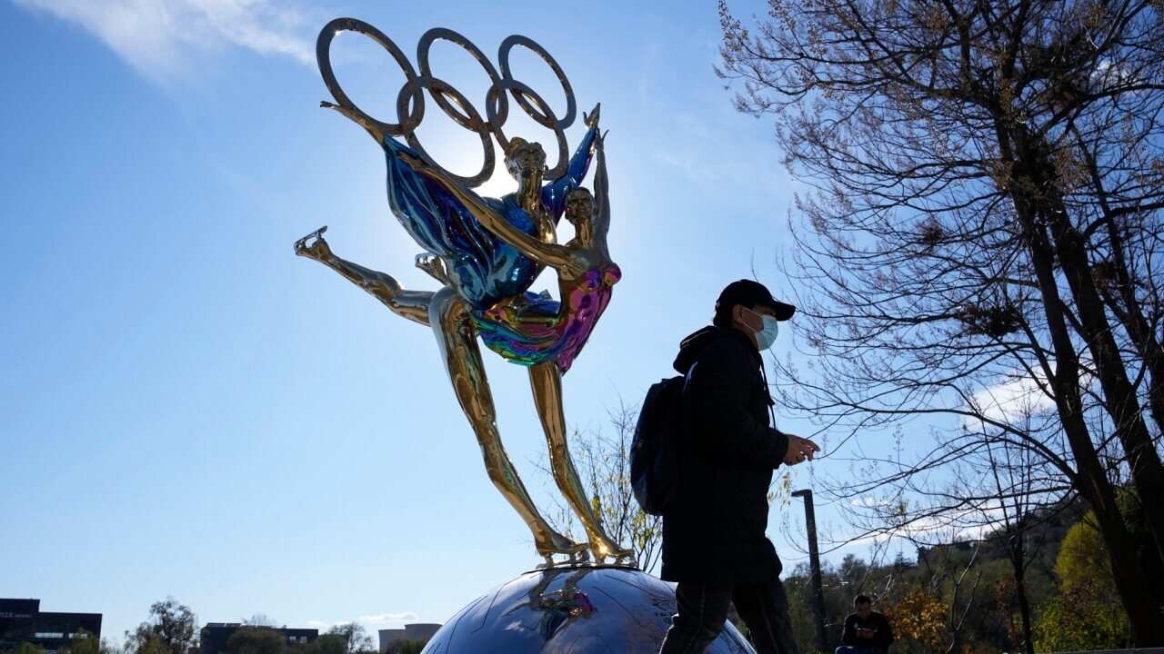 A visitor walks past a sculpture for the Beijing Winter Olympics