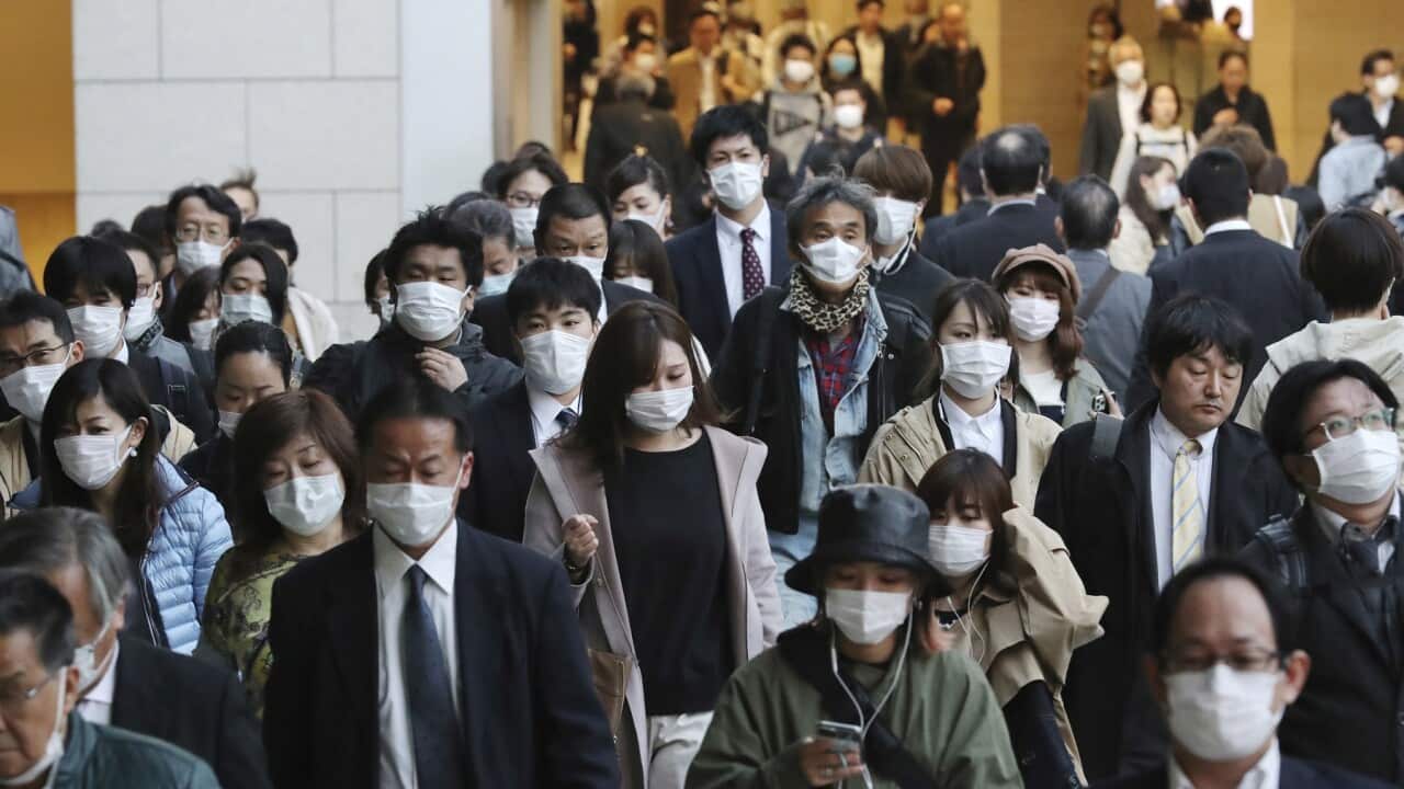 People wearing masks are seen near Umeda Station in Osaka on 7 April 2020. 