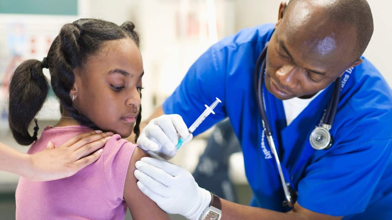 African American nurse giving patient injection