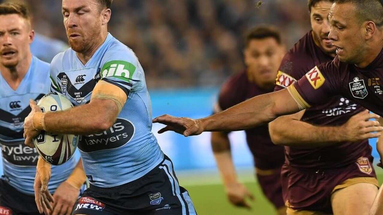 James Maloney of the Blues (second left) breaks a tackle.