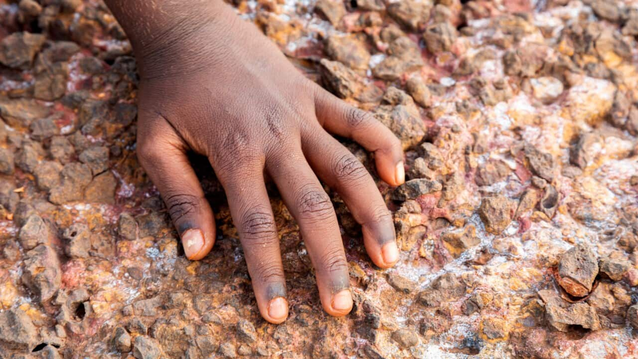 Single hand of a Young Indigenous girl on the rocks