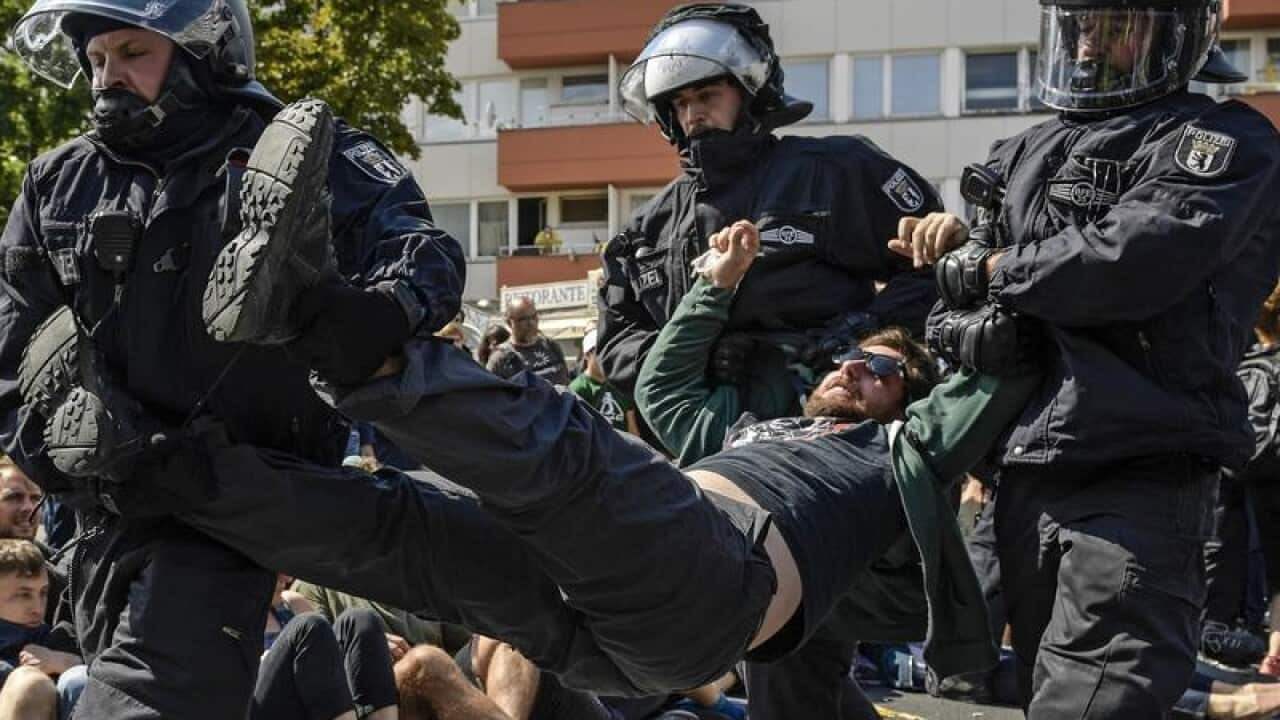 Police detain a counter-protester in Berlin