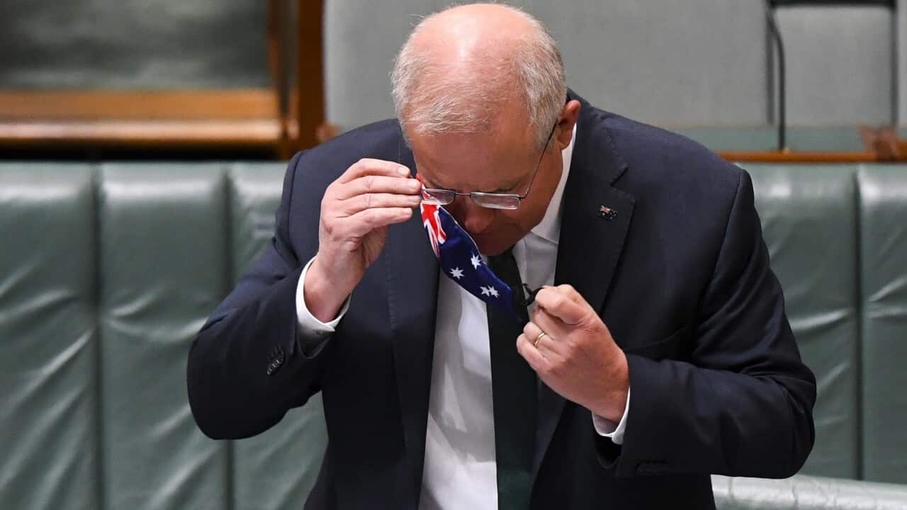Australian Prime Minister Scott Morrison removes his face mask during House of Representatives Question Time at Parliament House in Canberra.