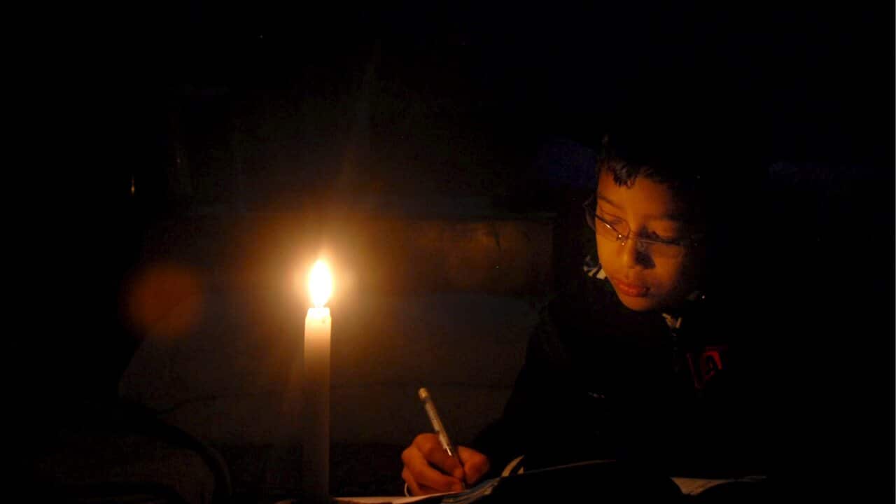 A young boy completes his homework using a candlelight during a load-shedding in Kathmandu, Nepal, 23 December 2008.EPA/NARENDRA SHRESTHA