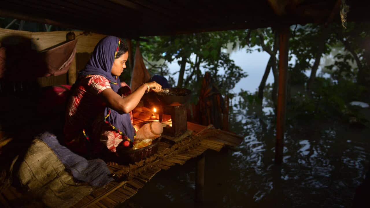 A woman cooks dinner in a makeshift camp in the Morigaon district of Assam, India
