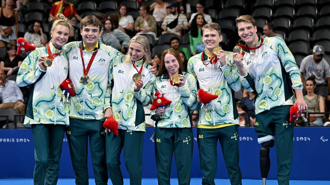 Team Australia swimmers react on the podium after winning Gold in the Mixed 4X100M Medley Relay.