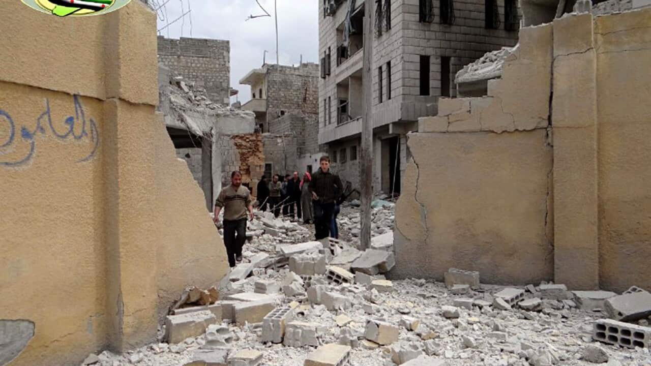 This photo posted by the anti-government activist website of the Syrian Observatory for Human Rights shows Syrians walking at the damaged backyard of a school after an airstrike, in Ansari neighborhood in Aleppo, Syria (Website of the Syrian Observatory f