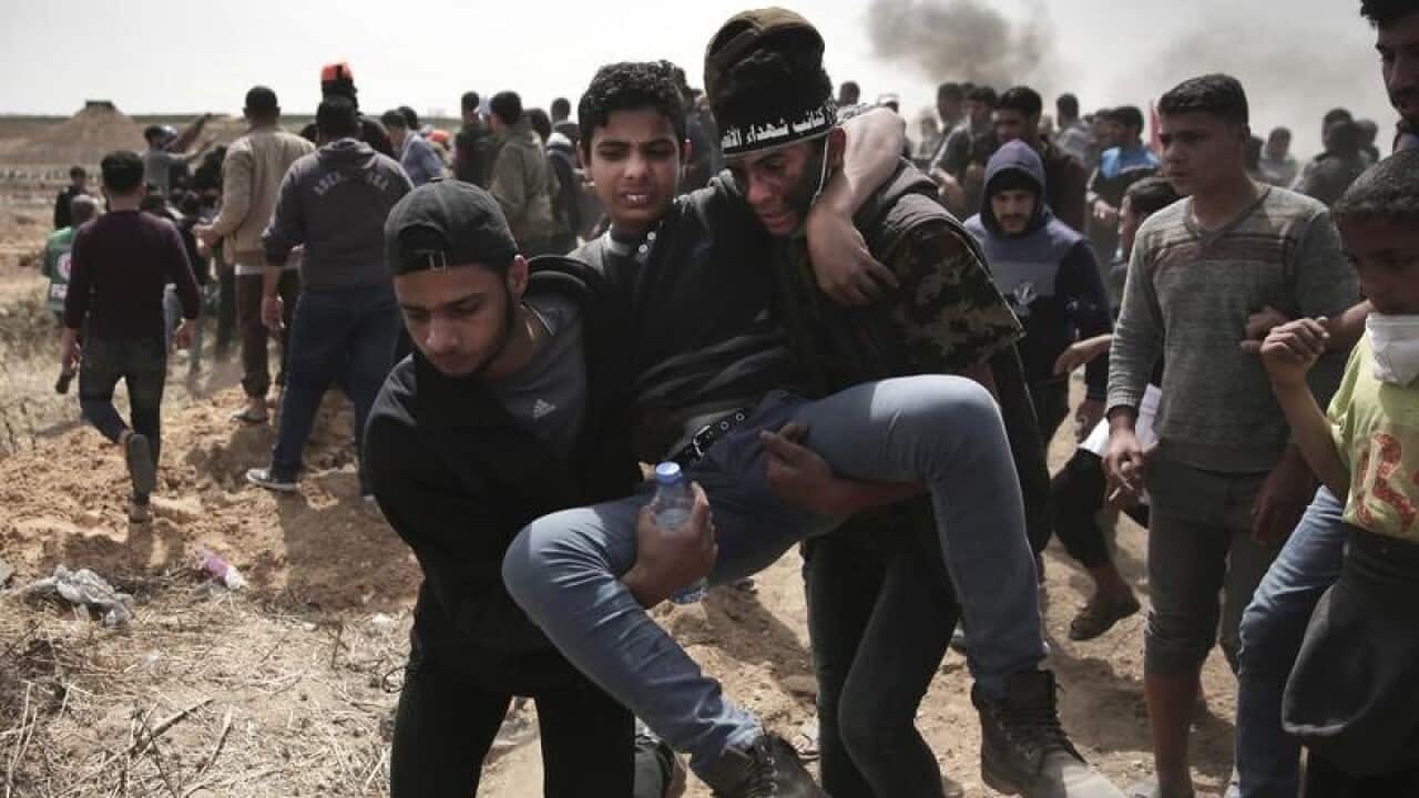Palestinian protesters evacuate a wounded youth.