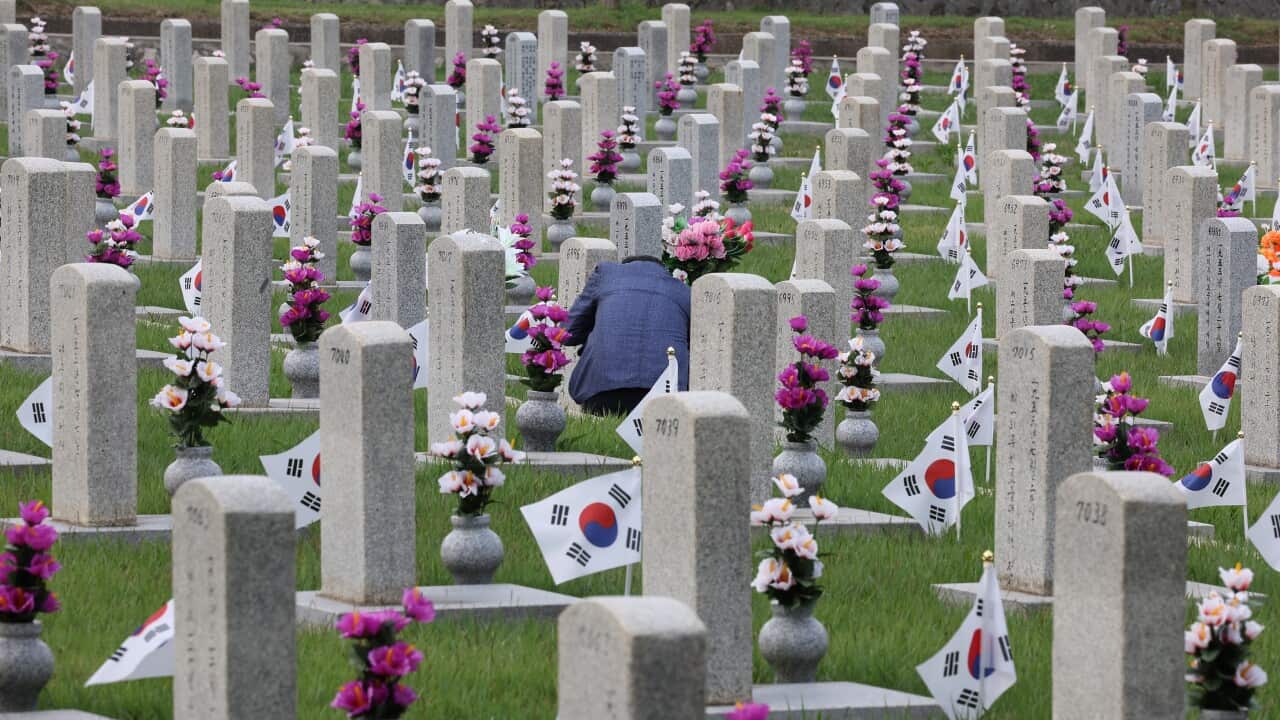 epa10033099 A visitor pays respects at a fallen soldier's grave at the national cemetery in Seoul, South Korea, 25 June 2022, the 72nd anniversary of the outbreak of the Korean War. EPA/YONHAP SOUTH KOREA OUT